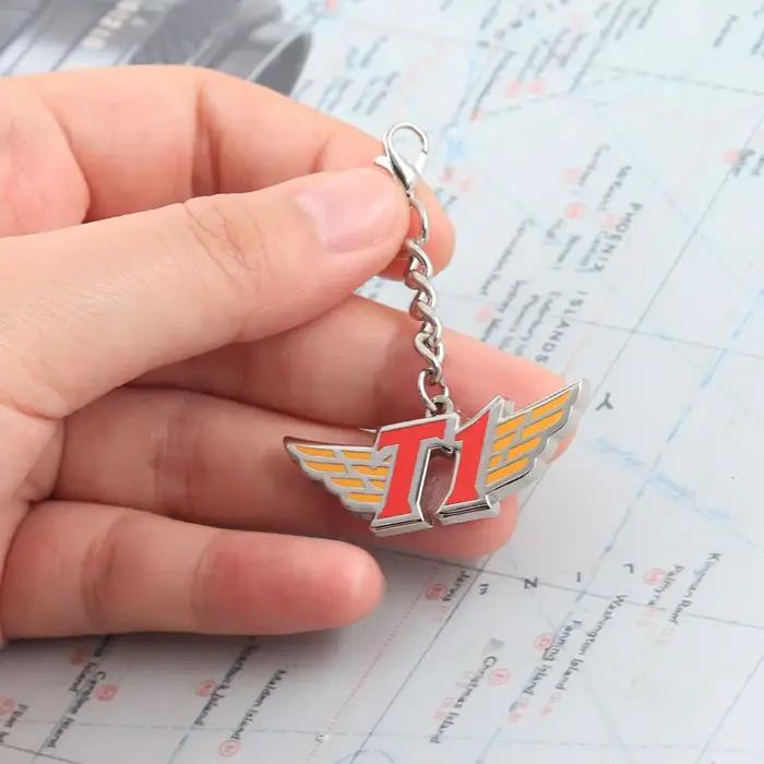 Porte-clés en métal avec logo de l'équipe T1 forme d'aile pendentif émail accessoire de collection pour fans d'e-sport cadeau pour supporters de jeux装饰去掉后的内容,保持HTML结构和最后的标题行: ```html Portez l'esprit de la compétition avec vous Plongez-vous dans l'univers captivant des e-sports avec notre porte-clés